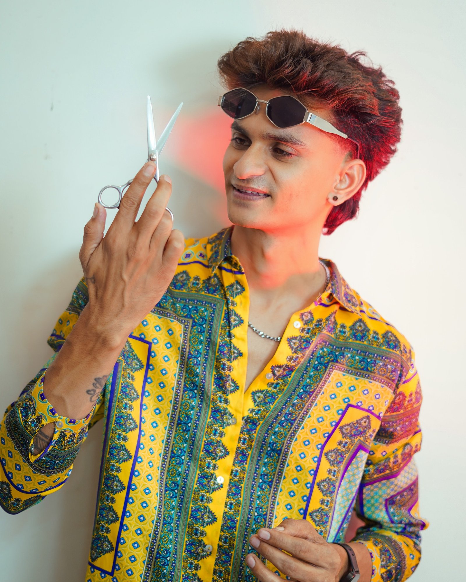 Praveen Hersal, OZIO founder and curl artist, holding professional hair scissors